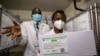 Technicians show a carton of AstraZeneca COVID-19 vaccine manufactured by the Serum Institute of India, inside a cold storage room at the central vaccine depot in Kitengela town on the outskirts of Nairobi, Kenya, March 4, 2021.