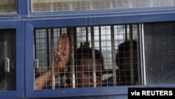 A man flashes the three-finger salute after being arrested during a protest against the military coup in Mawlamyine, Myanmar, Feb. 12, 2021. 