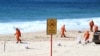 Workers in protective clothing clean up unknown debris washed up on Coogee Beach, Sydney, Oct. 17, 2024. (AAP/Dan Himbrechts via Reuters)