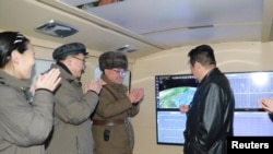 북한 조선중앙통신이 지난달 공개한 김정은(오른쪽) 국무위원장의 '극초음속 미사일' 시험 발사 참관 현장. (자료사진)