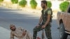 Fighters from a coalition of rebel groups called "Jaish al Fateh" rest with their weapons in the Hama countryside, Syria, July 29, 2015.