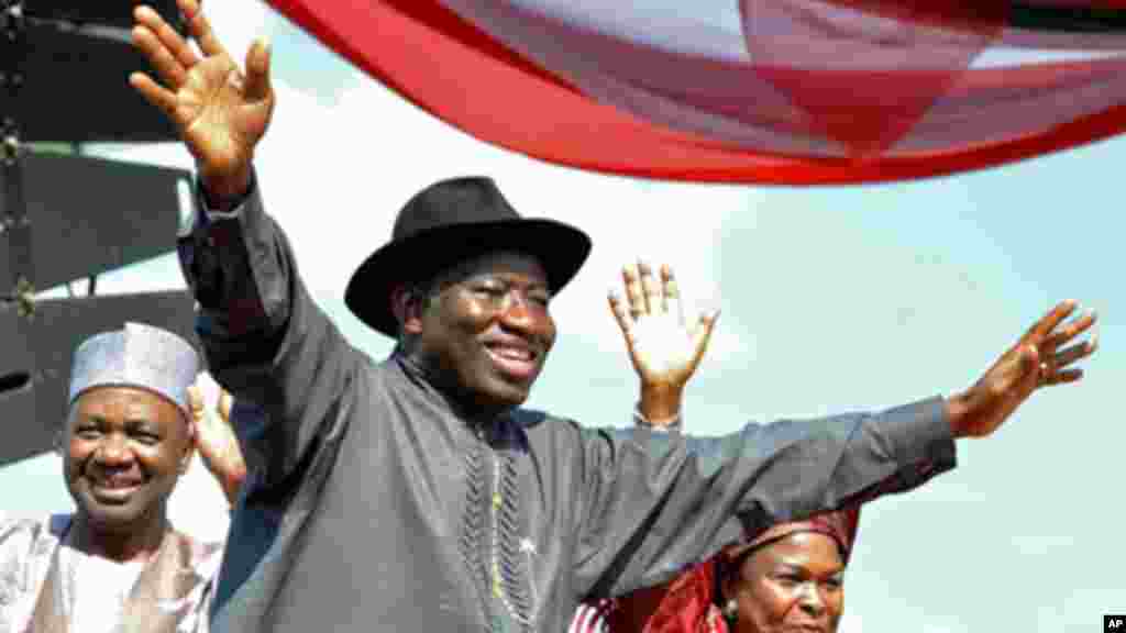 Shugaban kasar Najeriya Goodluck Jonathan (C),tare da matarshi Patience (R), Mataimakin shugaban kasa Namadi Sambo, yana dagawa jama'a hannu kafin kaddamar da kamfen dinsa a Abuja.