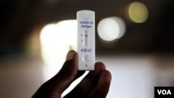 A man holds a Covid-19 testing kit at a private health facility in Harare, Zimbabwe, Thursday, Feb, 3, 2022. African nations have very limited access to COVID-19 tests, especially at-home tests. (AP)