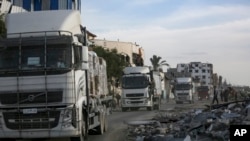 Sejumlah truk yang membawa bantuan kemanusiaan bergerak melalui perbatasan Kerem Shalom dari Mesir menuju Jalur Gaza, pada 19 Januari 2025. (Foto: AP/Jehad Alshrafi)
