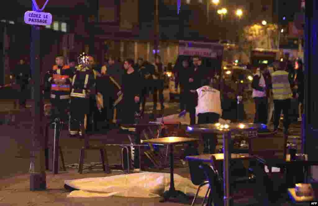 Rescue workers and medics work by victims in a Paris restaurant, Nov. 13, 2015. 