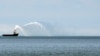 Sebuah kapal tambak menyalakan meriam airnya ke Laut Kaspia di dekat pelabuhan di Baku, Azerbaijan, pada 7 Juni 2021. (Foto: AP/Darko Vojinovic)