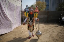 FILE - An Indian artist dressed as Hanuman, leaves for a religious procession in New Delhi, April 12, 2019.