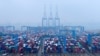 FILE - Containers and trucks are seen on a snowy day at an automated container terminal in Qingdao port, Shandong province, China, Dec. 10, 2018. 