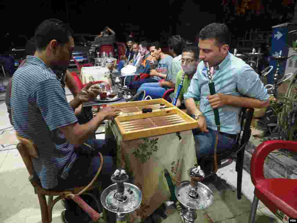 Enjoying traditional leisure activities, Egyptians play backgammon and smokes Shisha on Friday, 3 June 2016. (Photo: Hamada Elrasam for VOA)