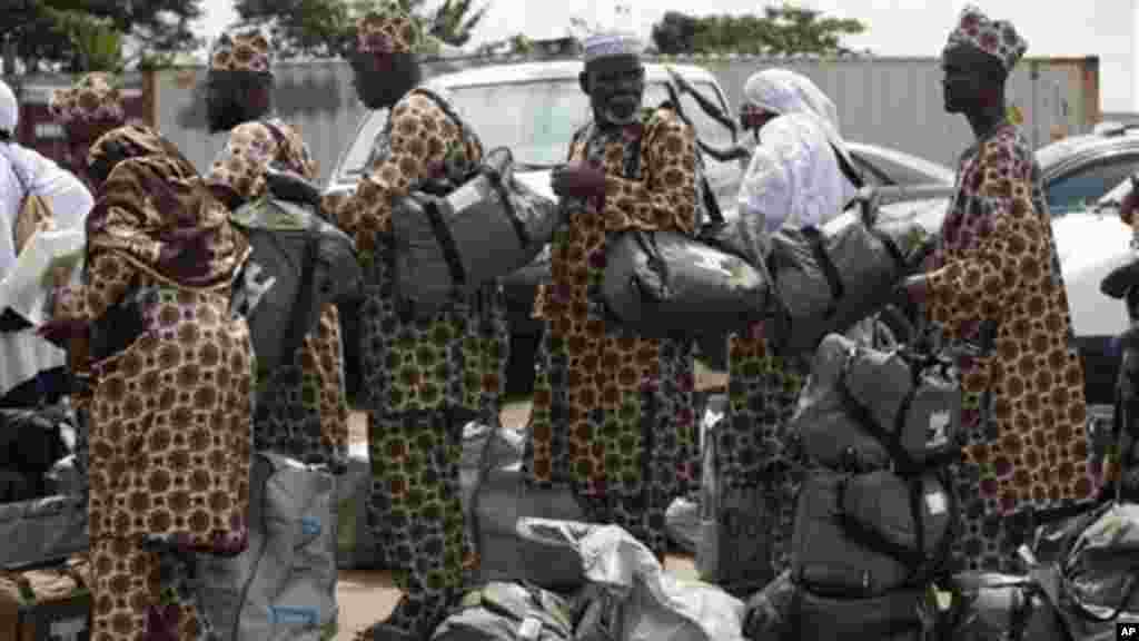 Mahajjata na tsaye a wani sansanin alhazai su na jira a yi mu su gwajin cutar Ebola kafin su shiga jirgin saman zuwa Saudiyya, a ranar goma sha takwas ga watan satumba shekarar dubu biyu da goma sha hudu, 18 ga Satumba, 2014.