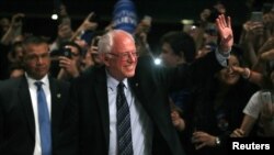 Kandidat capres AS dari Partai Demokrat, Bernie Sanders melambaikan tangan kepada para pendukungnya di Miami, Florida, pada malam menjelang pemilihan di negara bagian Michigan, Mississippi (8/3). 