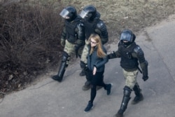 Police officers detain a demonstrator as they prevent an opposition action to protest the official presidential election results in Minsk, Belarus, March 27, 2021.