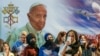 Women wait outside the Chaldean Cathedral of Saint Joseph, in Baghdad, Iraq, March 6, 2021, where Pope Francis, shown on a giant poster in the backround, officiated mass. 