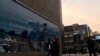 FILE - People walk past an advertisement near the flagship store of Canadian luxury parka maker Canada Goose in Beijing, China, Dec. 31, 2018. 
