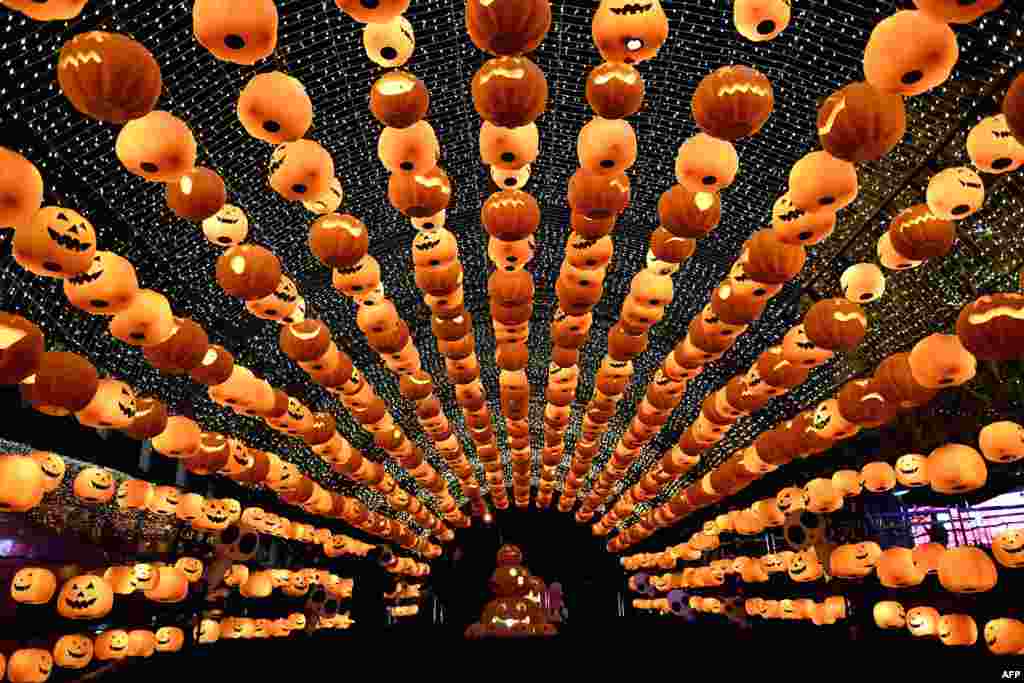 Visitors walk past a pumpkin lantern show in front of a shopping mall to mark Halloween in Shenyang, northeast China's Liaoning province.