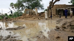 Wani hoto na kungiyar Oxfam da aka dauka ranar 17ba watan Augustan 2010 ya nuna mutane tsaye a kusa da wasu gidajen da ambaliyan ruwa ya rushe a birnin Zinder.