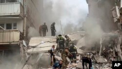 Para petugas SAR sedang bekerja di lokasi gedung yang setengah roboh terkena serangan misil oleh Angkatan Bersenjata Ukraina di Kota Belgorod, Rusia, 12 Mei 2024. (Foto: Gubernur Belgorod Vyacheslav Gladkov via AP)